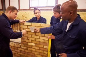 construction teacher and students build wall